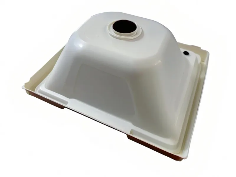 A white plastic sink trap viewed from below with an opening for drainage connection.
