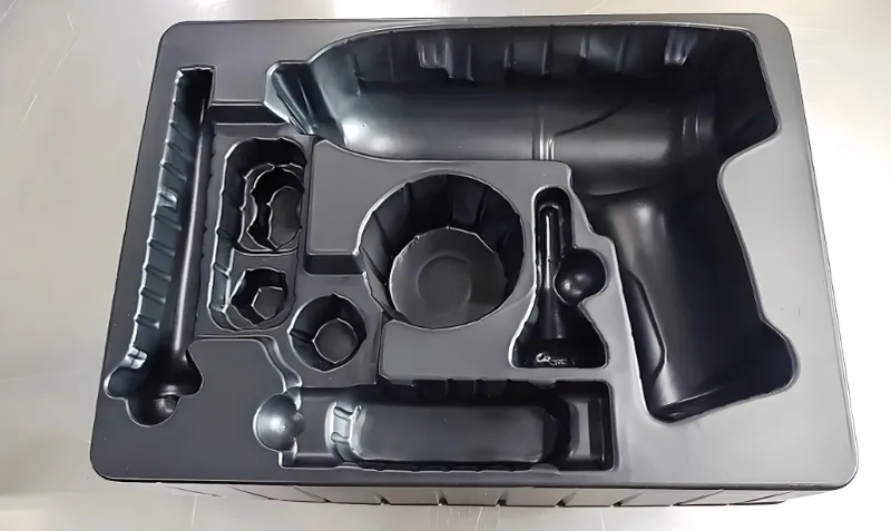 A black plastic insert tray with molded compartments for holding various items, such as tools or accessories