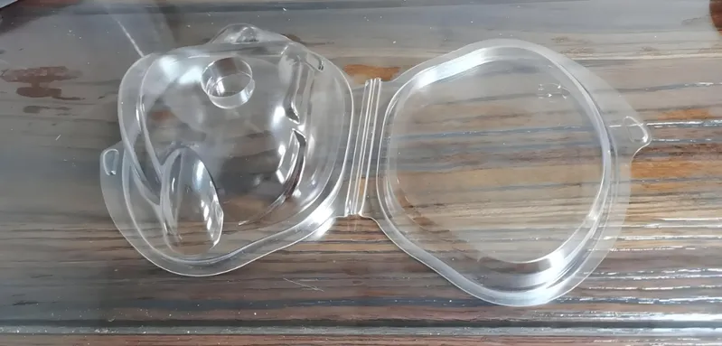 Open plastic clamshell packaging on a wooden surface