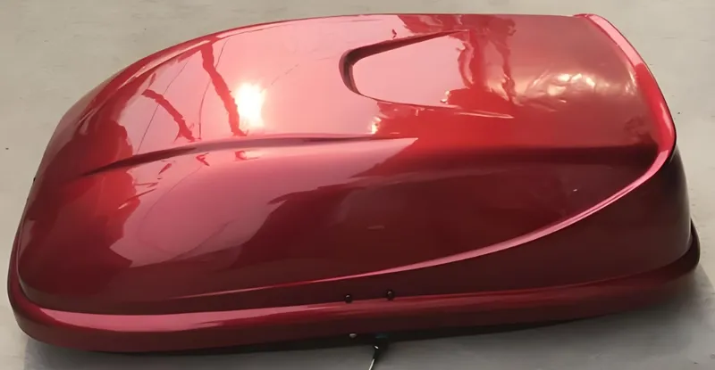 Kotak atap mobil berwarna merah mengkilap dengan desain yang ramping