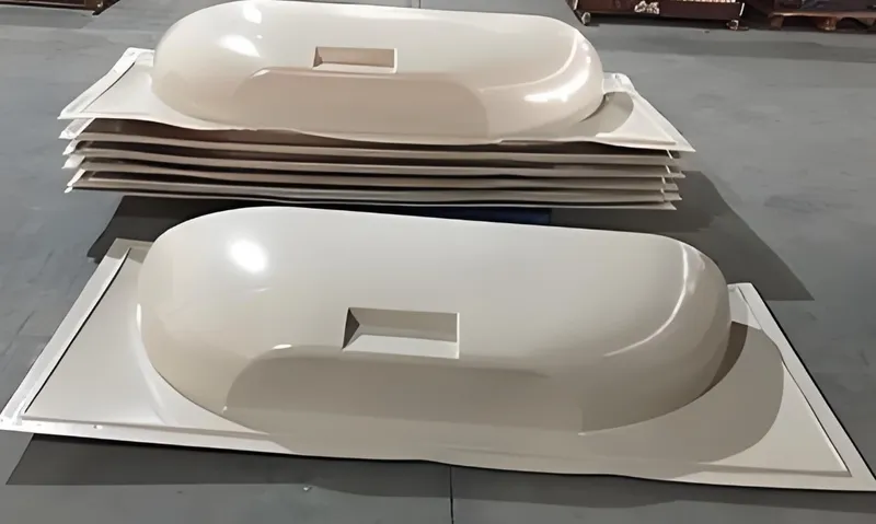 Several stacked fiberglass domes on the floor in a warehouse