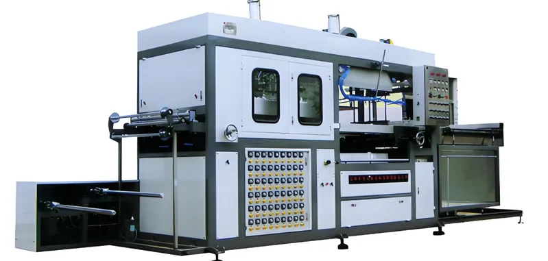 Large industrial plastic thermoforming machine with multiple control panels and rollers