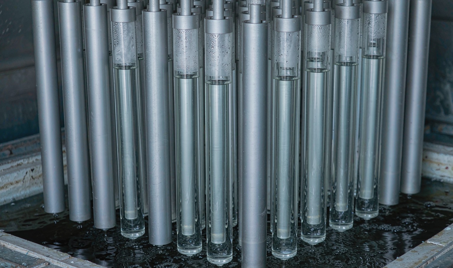 Cast acrylic rod production - aluminium tube moulds standing in a water bath polymerization tank