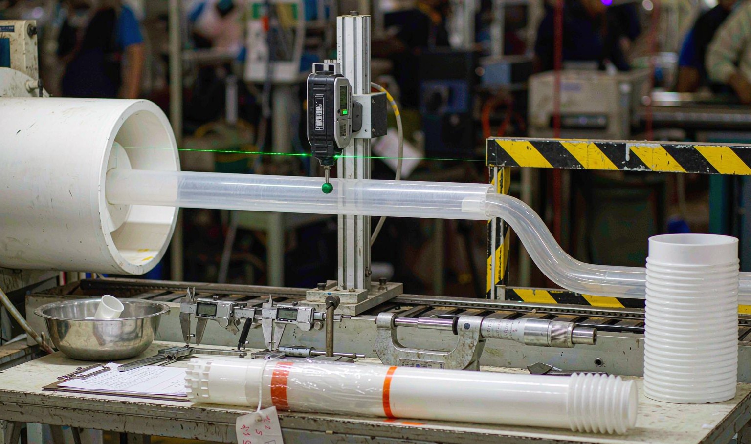 Quality control station on a plastic profile extrusion line with a laser diameter gauge, digital calipers and inspection records