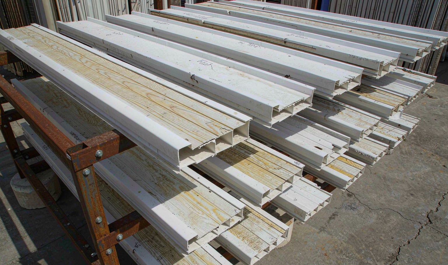 White and laminated PVC window profile samples on an outdoor weathering rack after several years of exposure